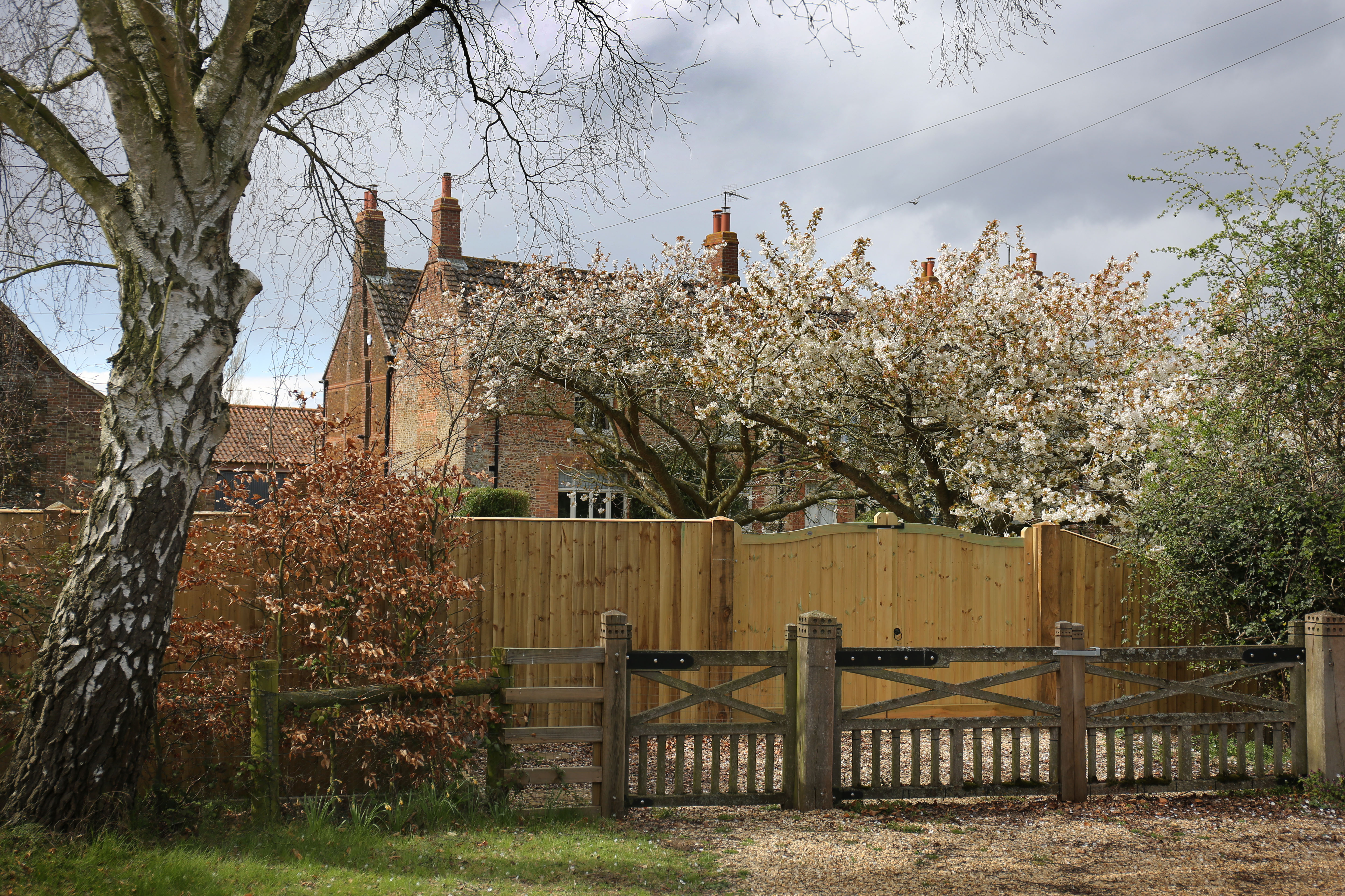 The exterior of Marsh Farm with flowering trees