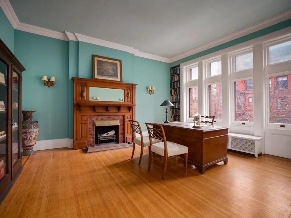 Bedroom with wooden flooring and wood-panelled fireplace
