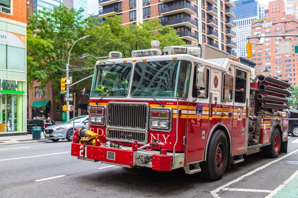 FDNY fire truck driving down a street in New York City.