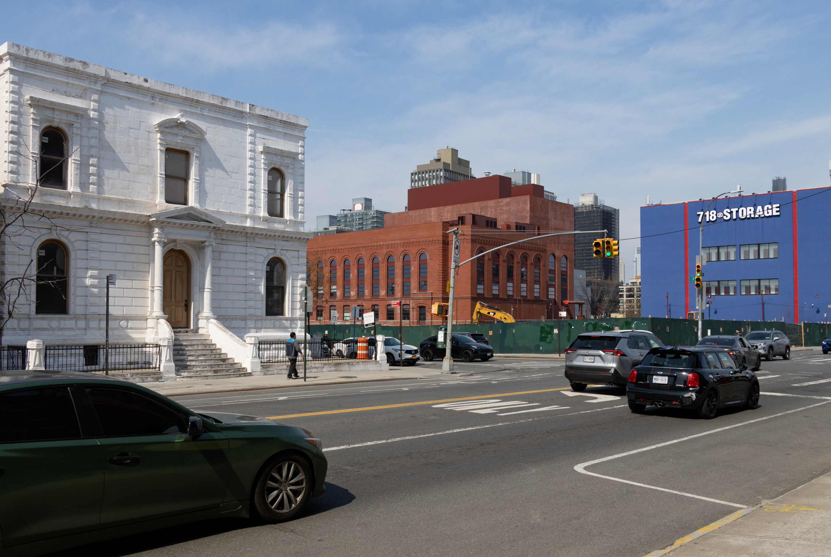view along 3rd avenue showing white coignet stone building with the empty lot in the background