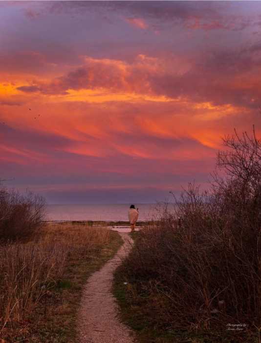 woman walking on a path during a sunset