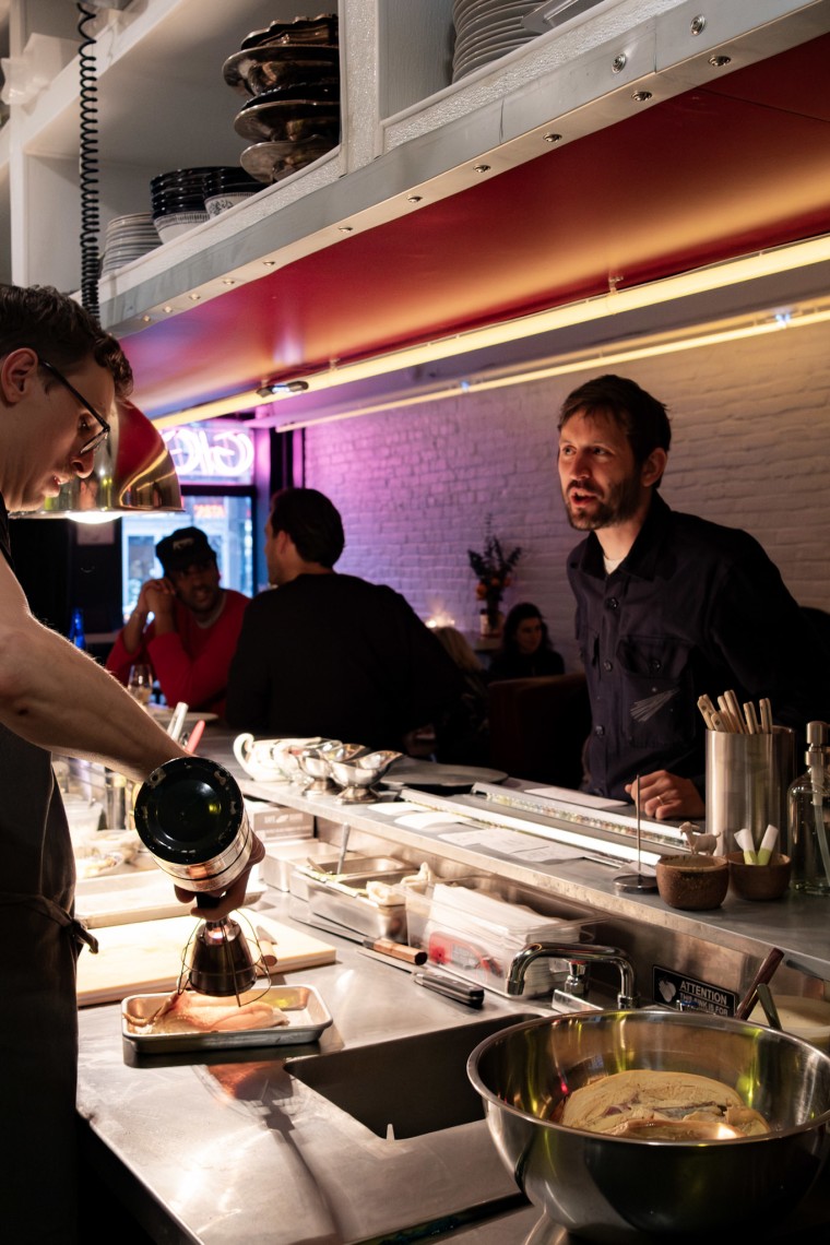 Gigi's owner Hugo Hivernat speaks over a counter to chef de cuisine Thomas Knodell.