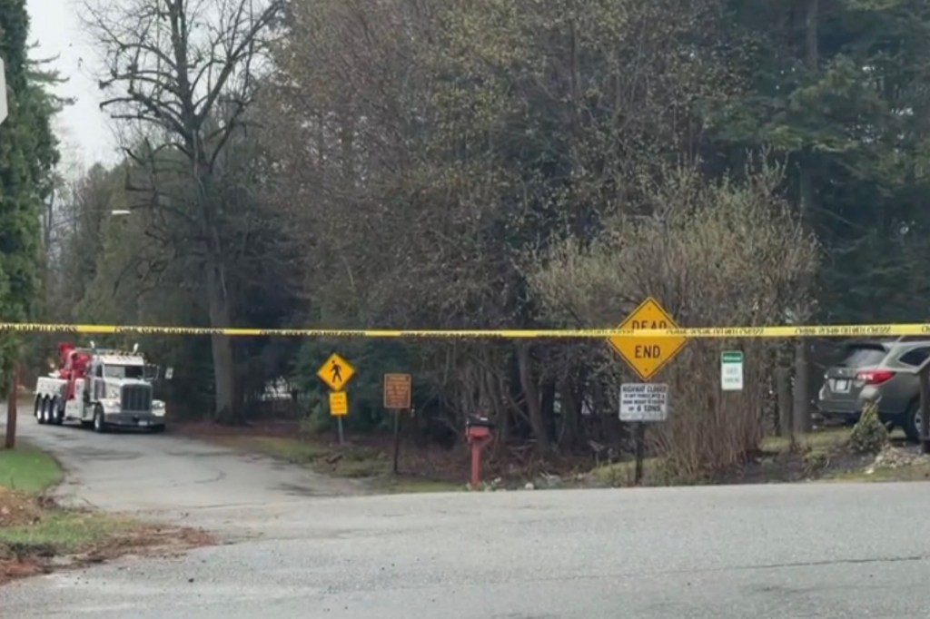 A tow truck on a road blocked by yellow caution tape.