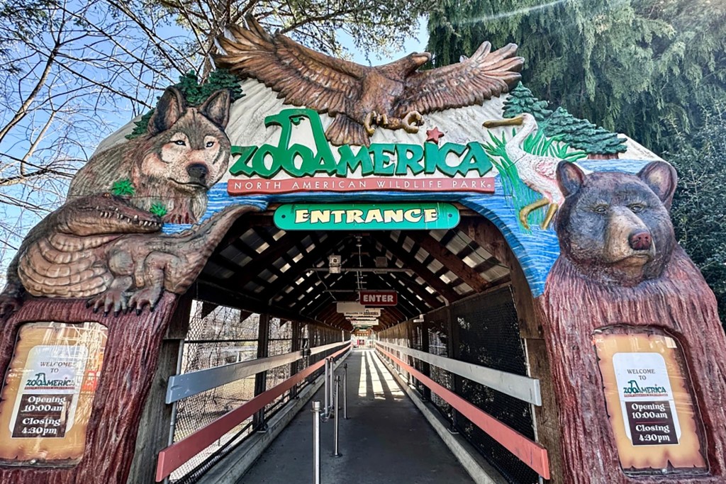 Entrance to ZooAmerica North American Wildlife Park, featuring carvings of a wolf, eagle, and bear.