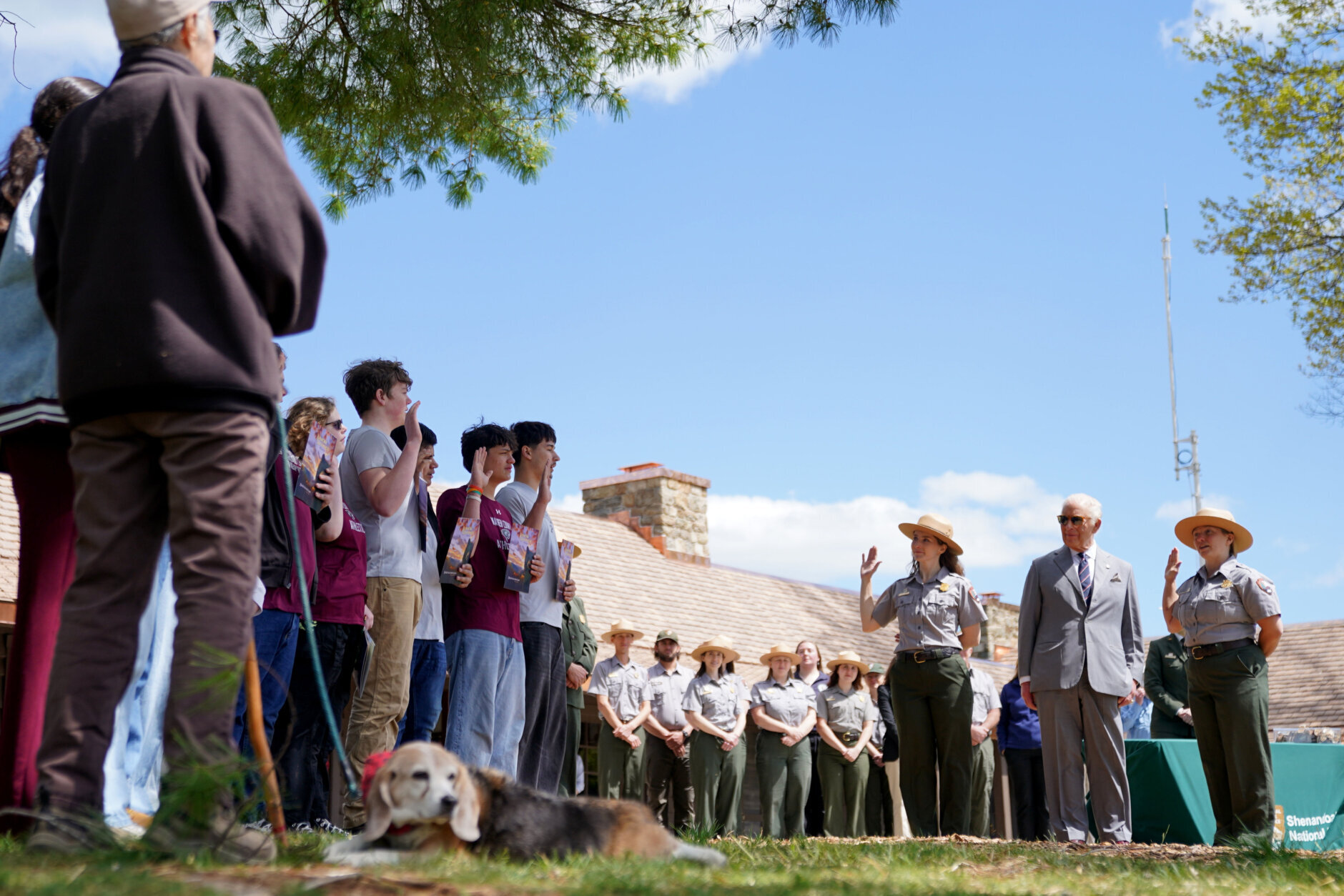 Britain's King Charles III looks on as students from Warren County High School are sworn in as junior park rangers, as they visit Shenandoah National Park in Front Royal, Va., Thursday, April 30, 2026. Bailey, the dog, foreground, is a BARK ranger. (AP Photo/Allison Robbert, Pool)