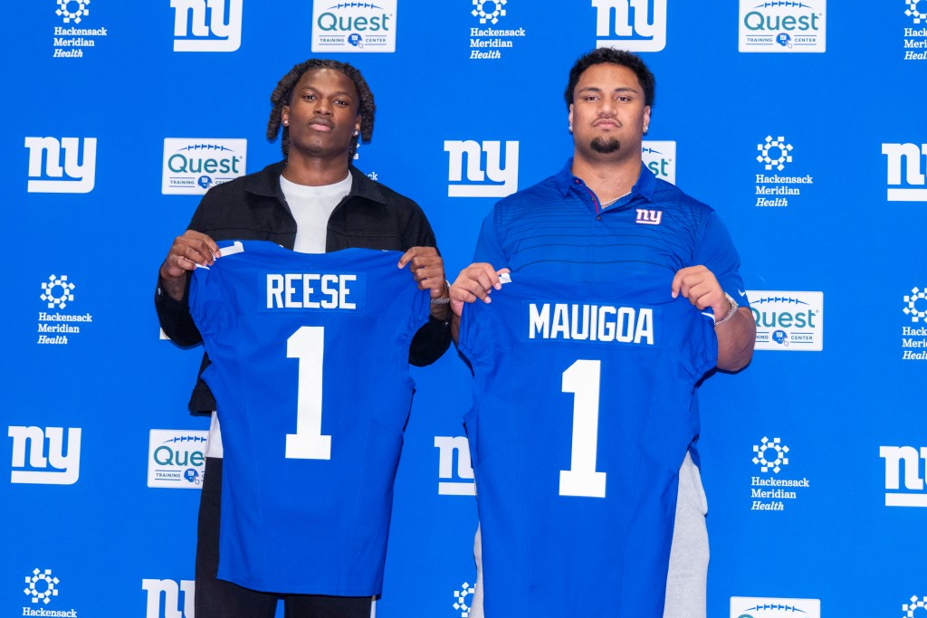 New York Giants draft picks Arvell Reese and Francis Mauigoa holding up their blue jerseys with their last names and the number 1.