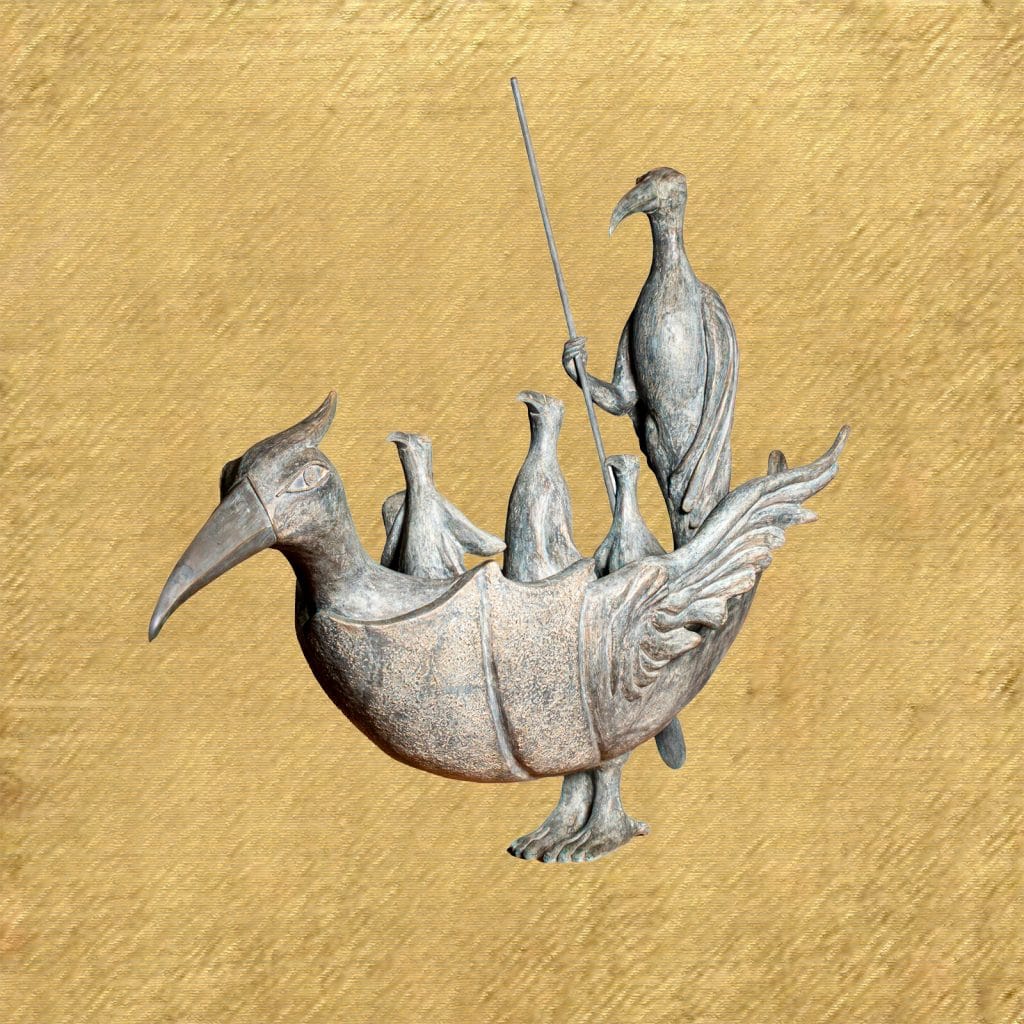 A surreal bronze sculpture by Leonora Carrington of a large bird-shaped vessel with a long beak and carved wings, carrying several smaller bird figures inside. A taller, bird-headed figure stands at the back holding a long staff, as if guiding the group. The sculpture has a weathered, grayish patina and is set against a flat, gold-toned background.