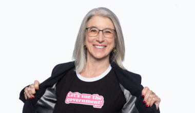Cindy Cohn wearing a t-shirt that says Let's Sue the Government
