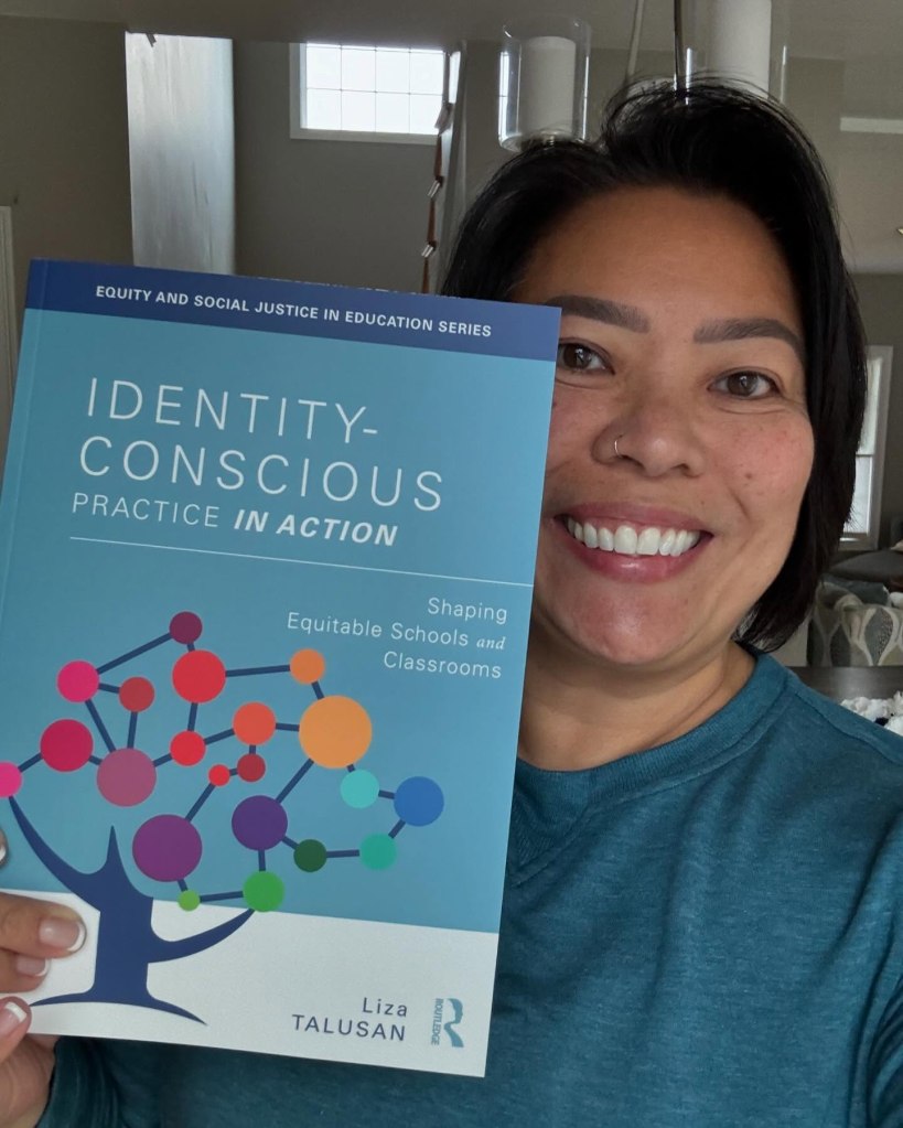 Liza Talusan holding her book, "Identity-Conscious Practice in Action: Shaping Equitable Schools and Classrooms."