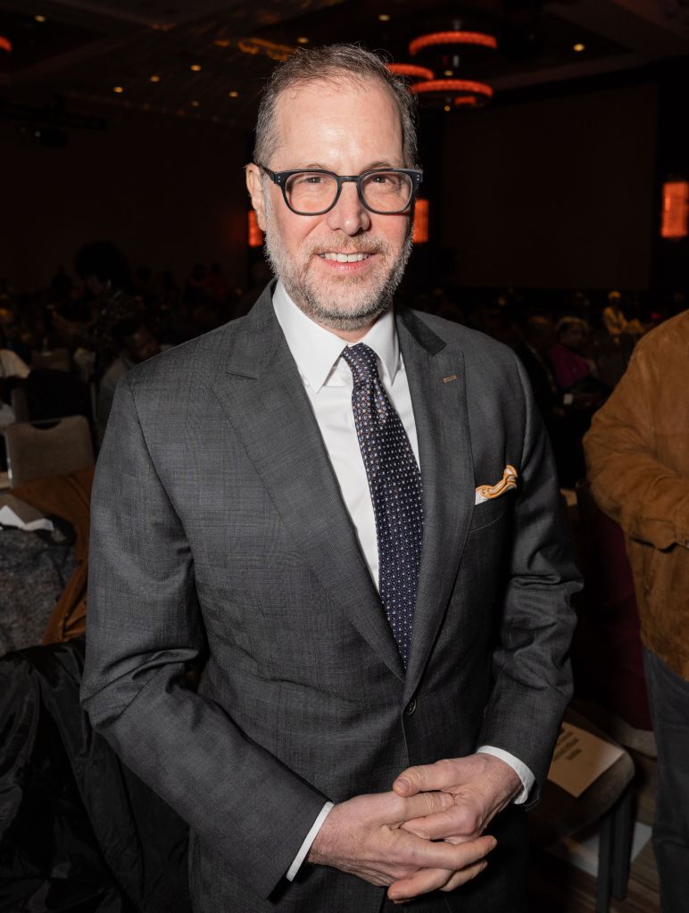 Mark Levine, a man in a gray suit and glasses, smiles at the NAN Convention.