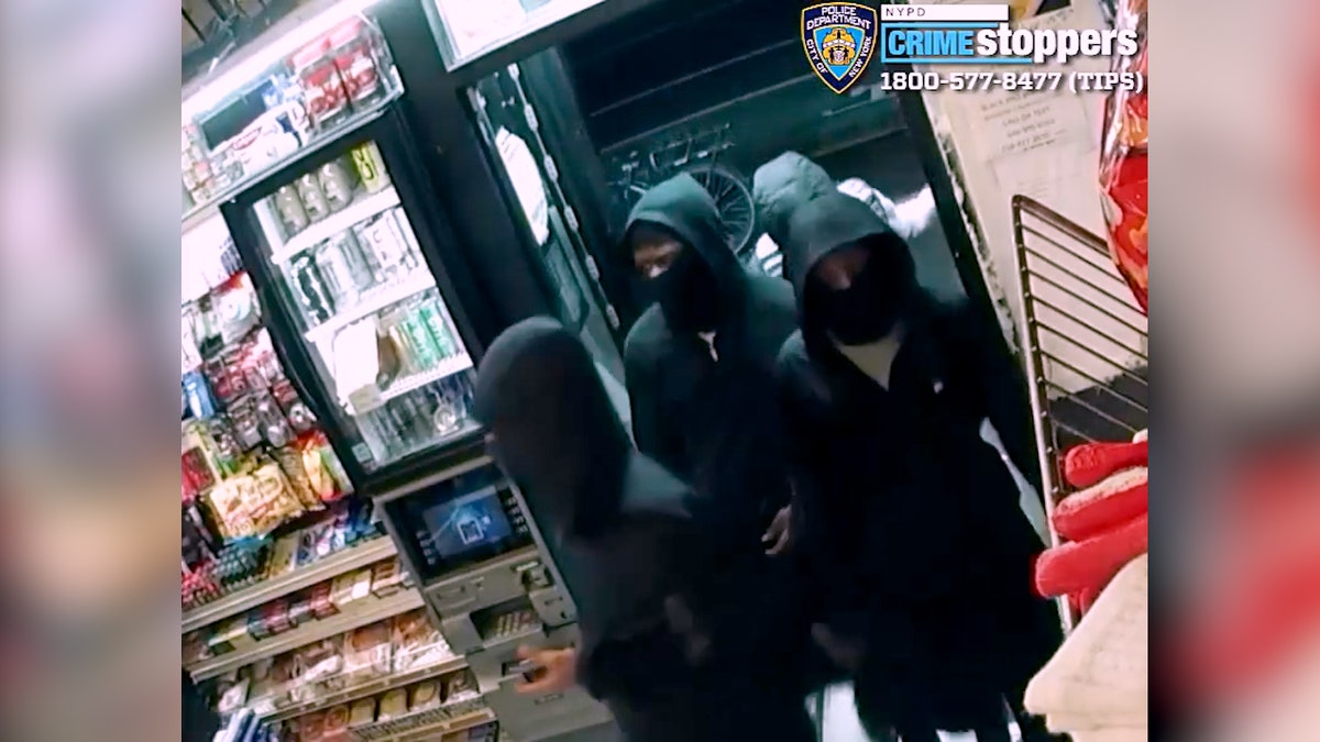 four people in black clothing enter store