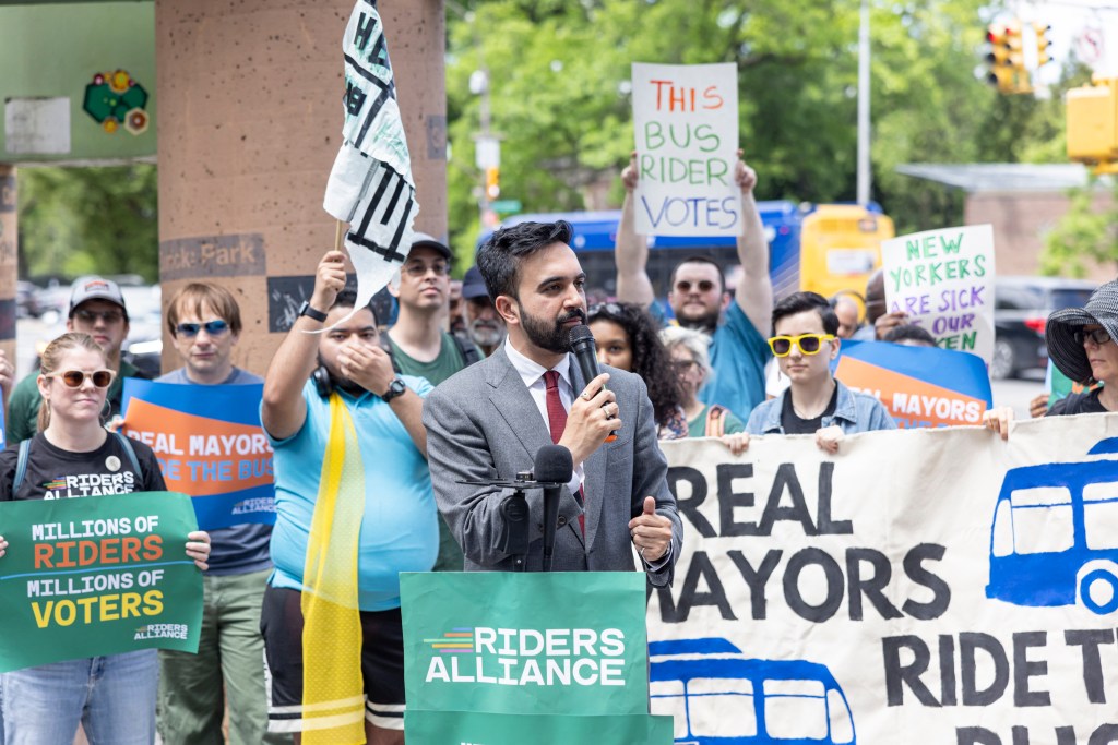 Zohran Mamdani speaking at a Riders Alliance rally in Flatbush, Brooklyn, advocating for improved mass transit.