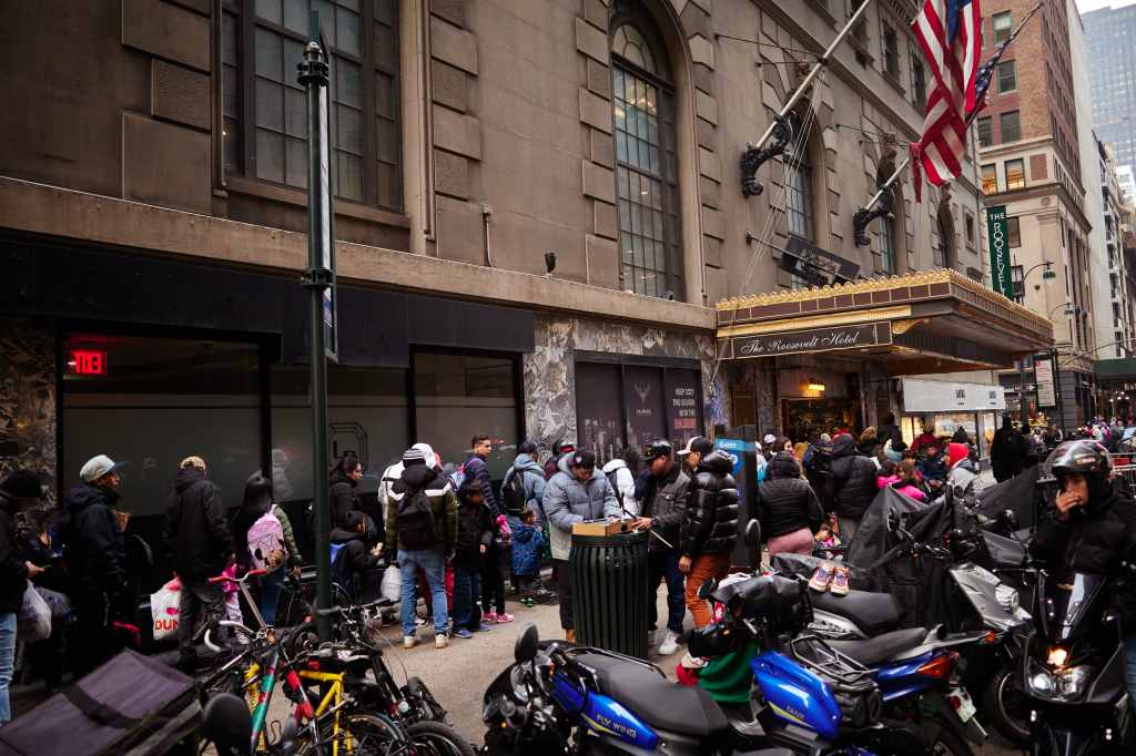 Migrants gather outside the Roosevelt Hotel in New York City.