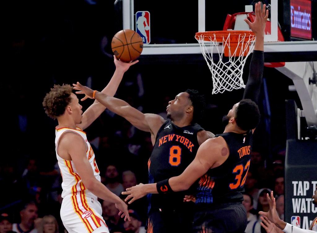 Atlanta Hawks guard Dyson Daniels attempting a shot while being defended by New York Knicks forward OG Anunoby and another Knicks player.