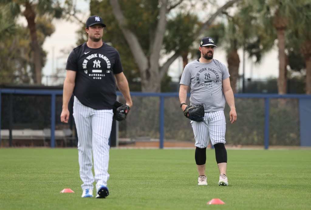 New York Yankees pitchers Gerrit Cole and Carlos Rodón walking on a field at spring training.