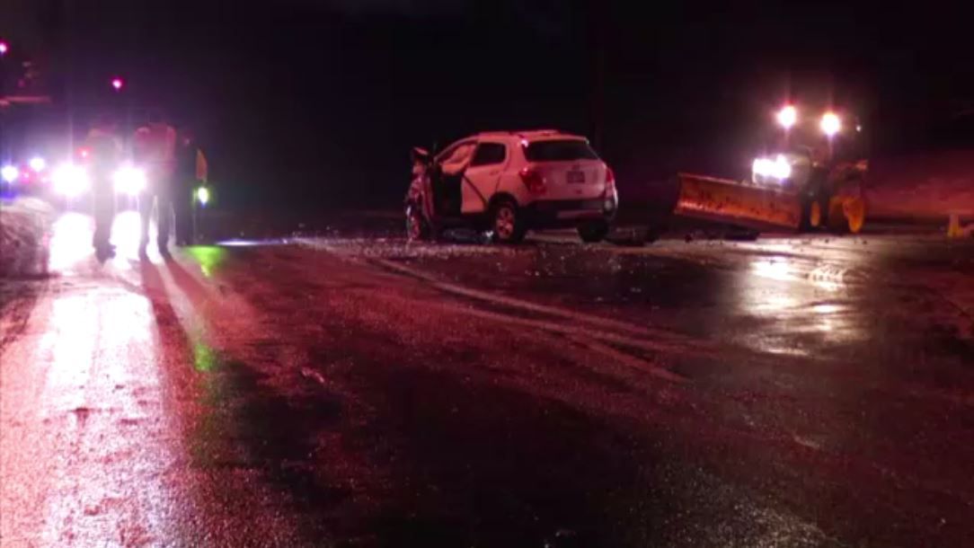 crews respond to car crash on route 7 in niskayuna new york at night. a white car involved in the crash is in the center of the road.