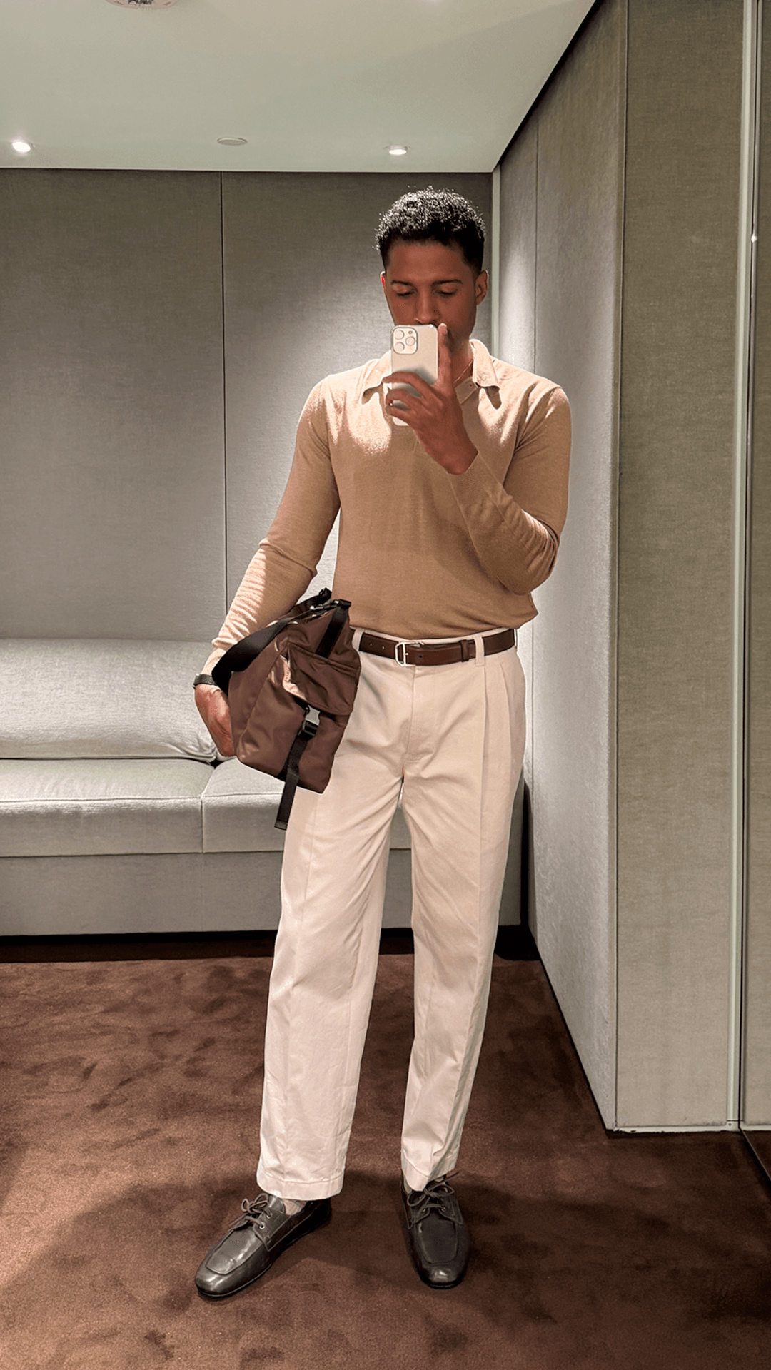 Image may contain Clothing Pants Adult Person Accessories Bag Handbag Shirt Formal Wear Face Head and Sleeve