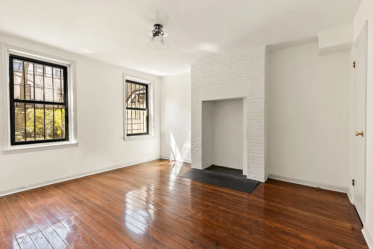 garden level bedroom with wood floor, two windows