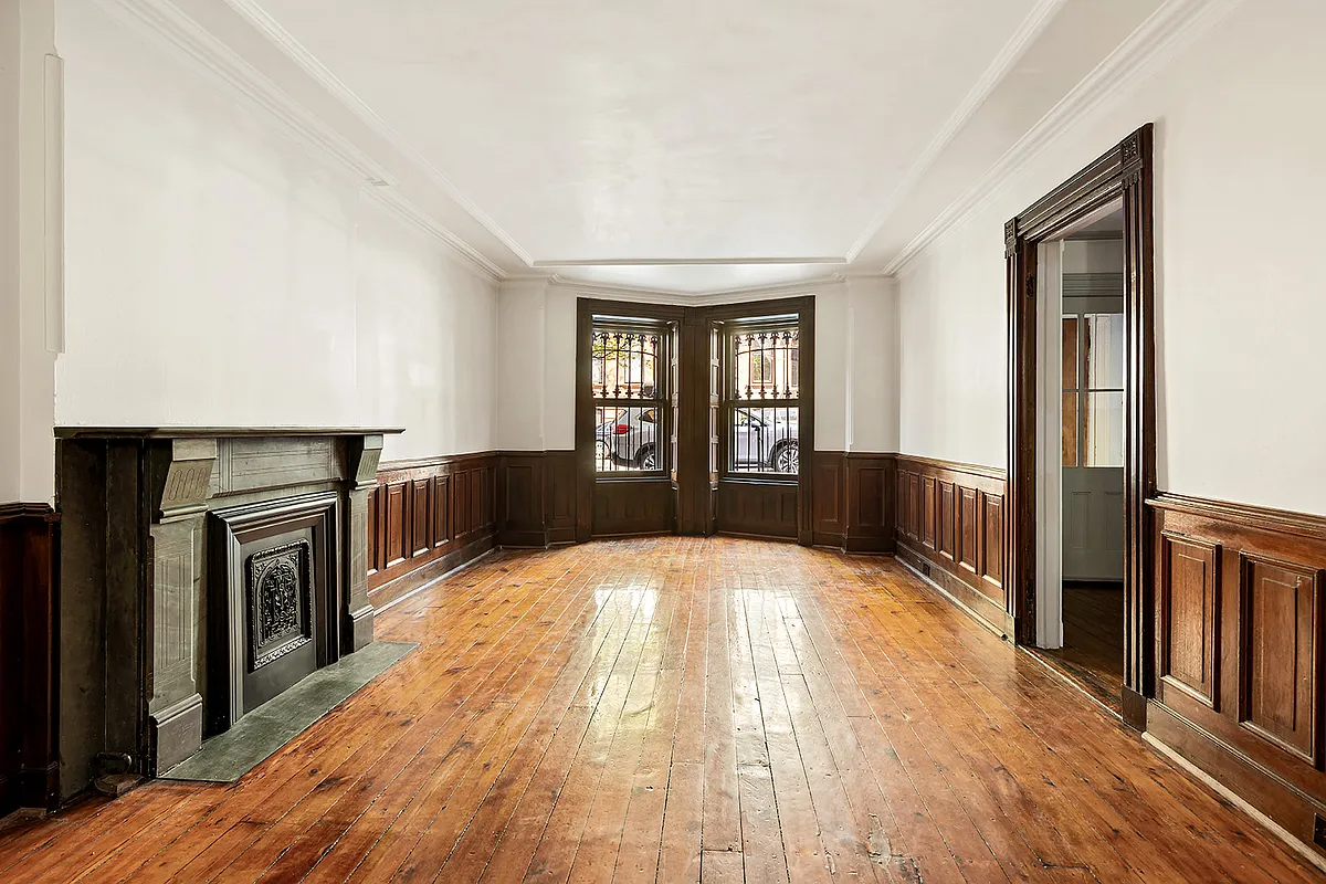 garden level apartment living room with wainscoting, stone mantel