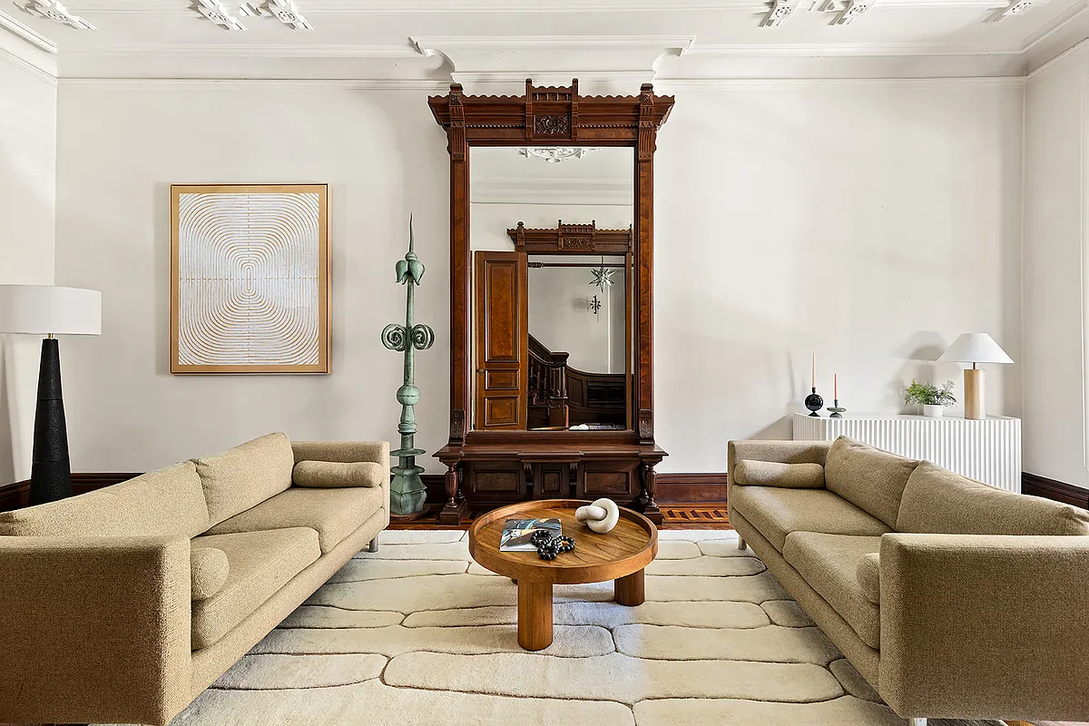 parlor with a pier mirror, wood floor, white walls