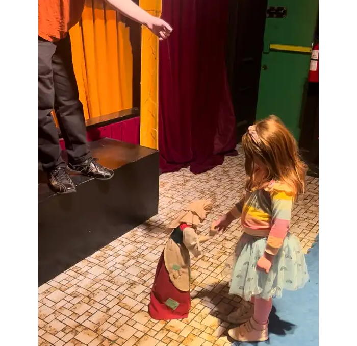 a child interacts with a puppet
