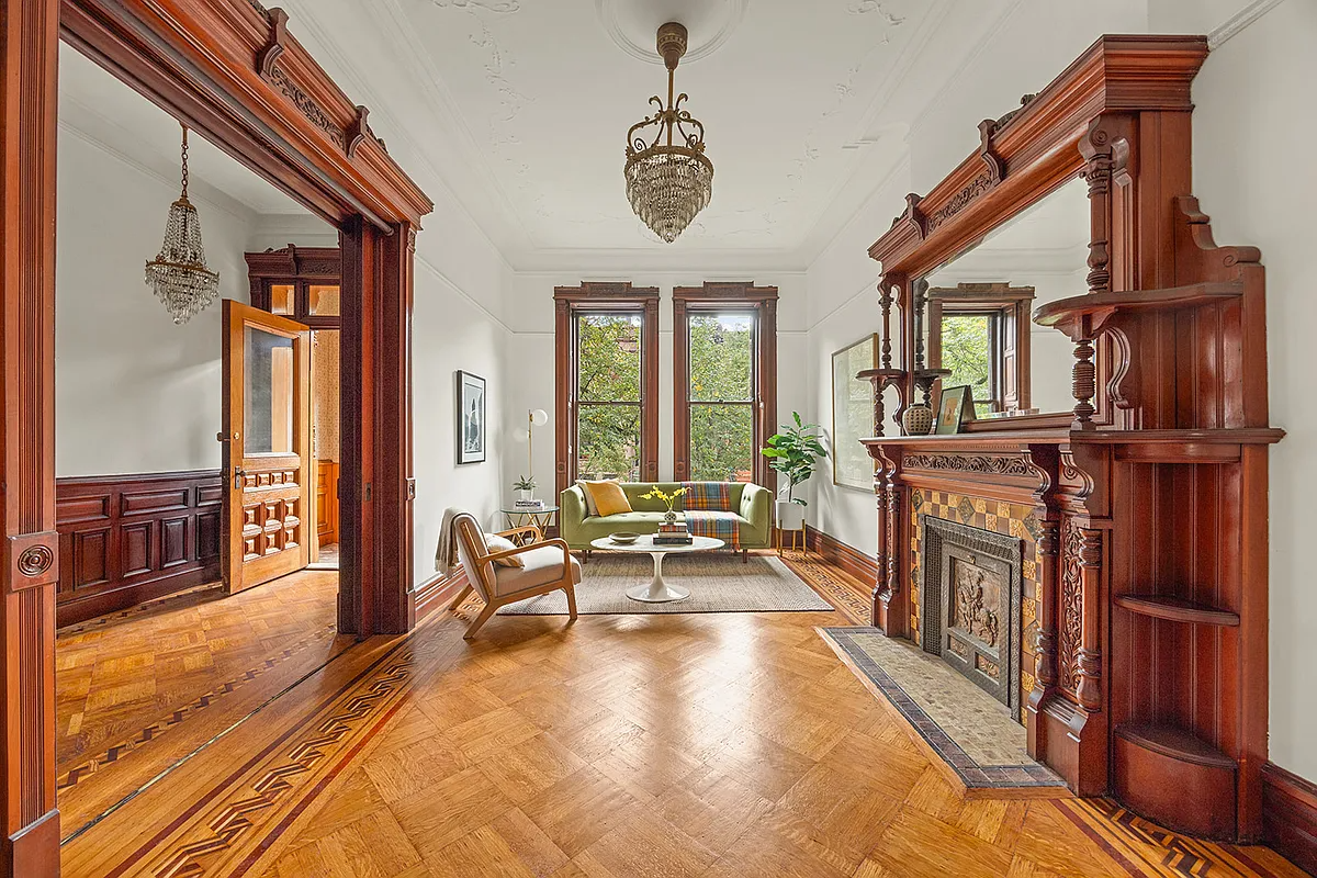 parlor with wood mantel, wood floor and moldings