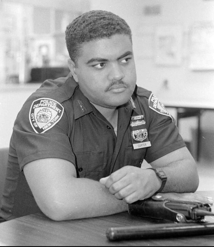 Black and white portrait of NYPD Officer Gerard Carter in uniform with "30176 CARTER" on his badge.