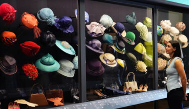 A member of the Royal Collection Trust staff looks towards hats, bags and shoes worn by Princess Elizabeth, on display at