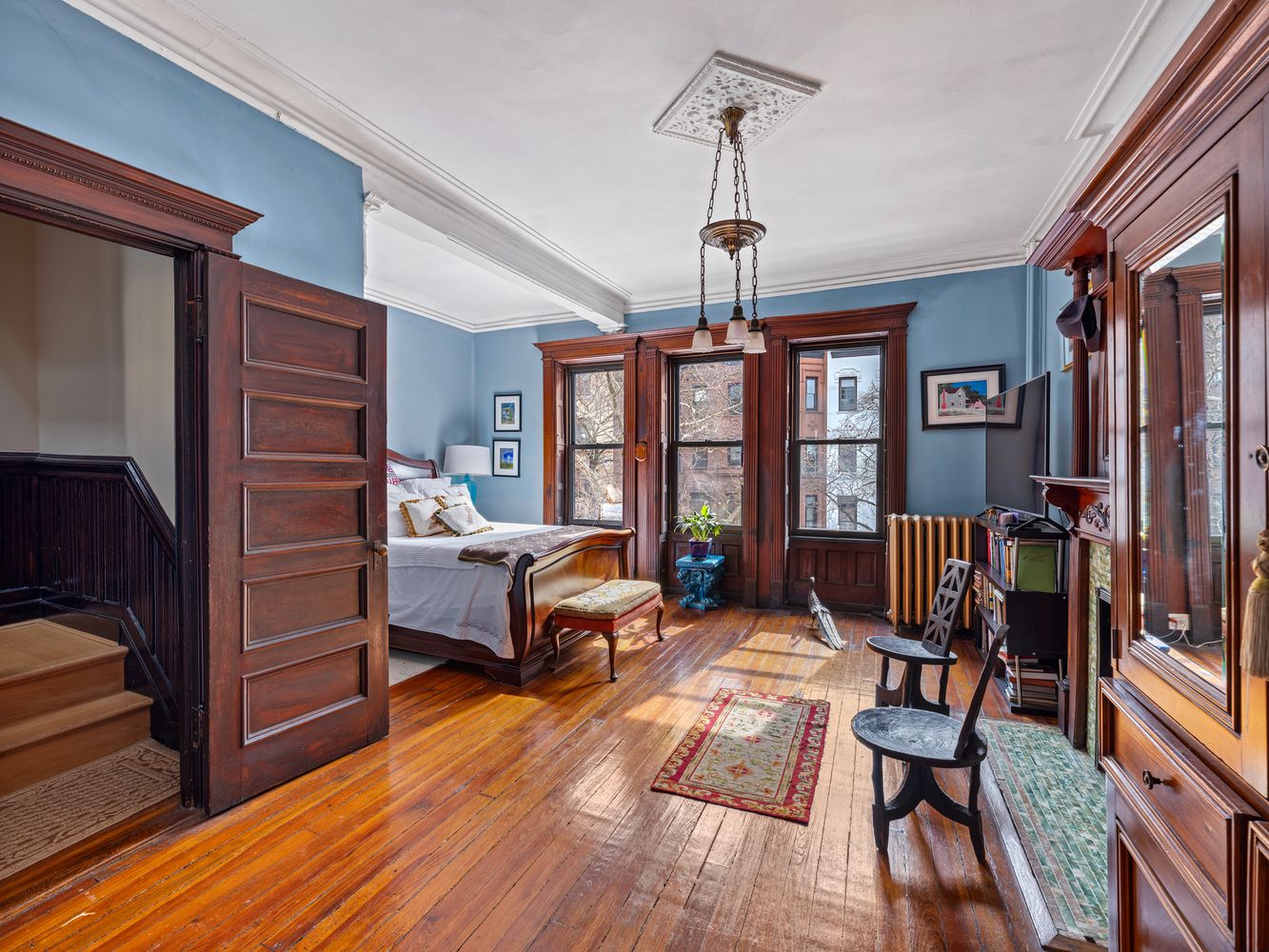 bedroom with a bed nook, ceiling medallion and a wood floor
