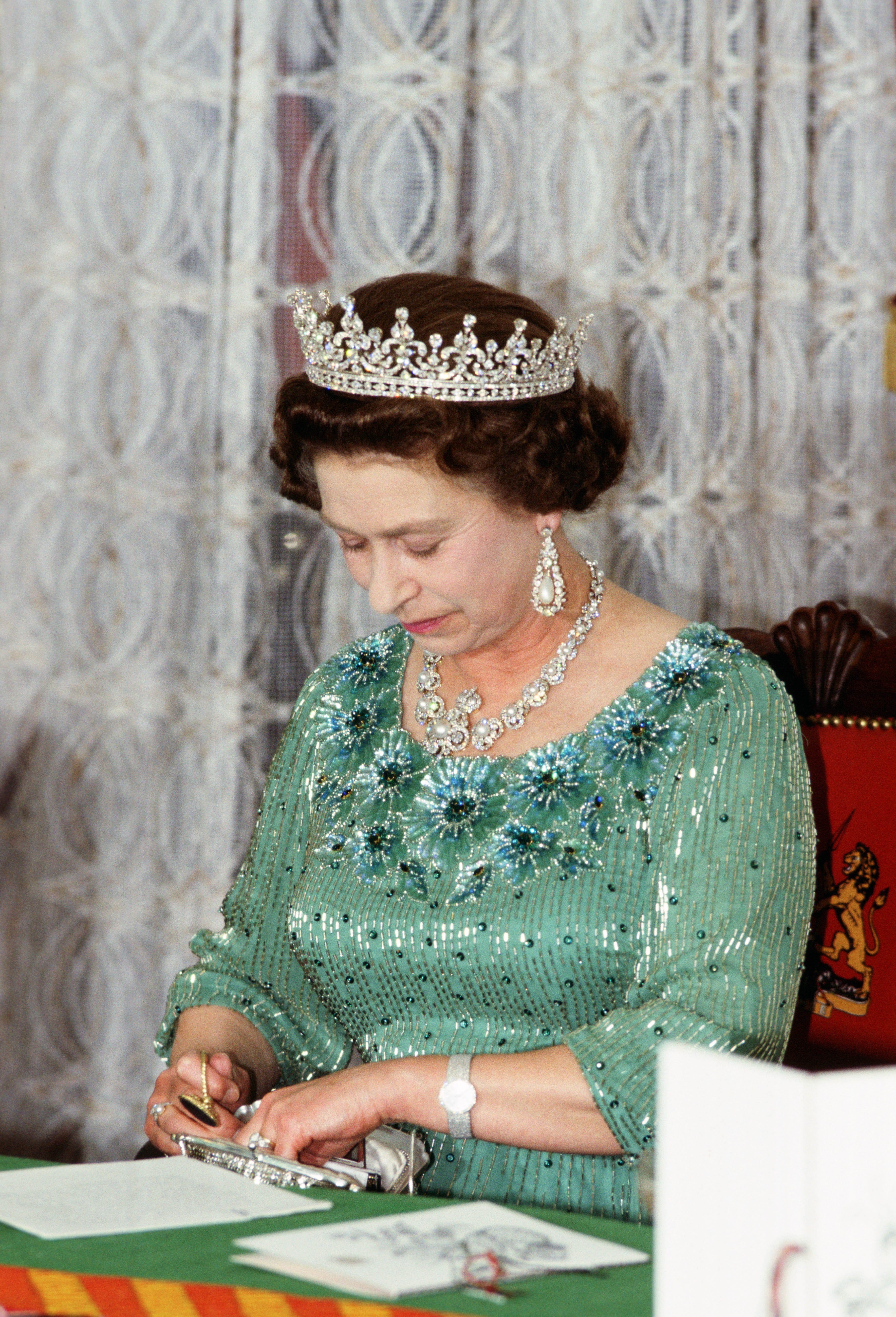 Queen Elizabeth II looks through her handbag during a banque