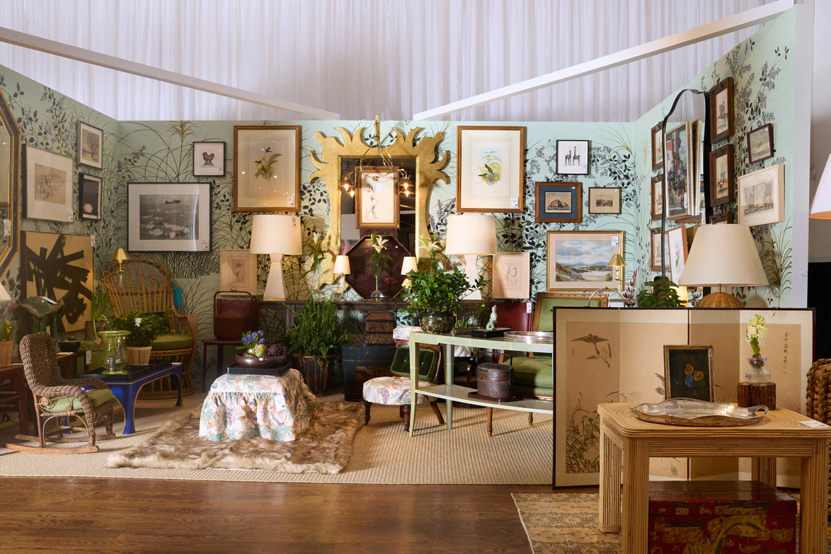 Eclectic living room filled with vibrant plants, decorative lamps, and framed artwork on patterned walls.