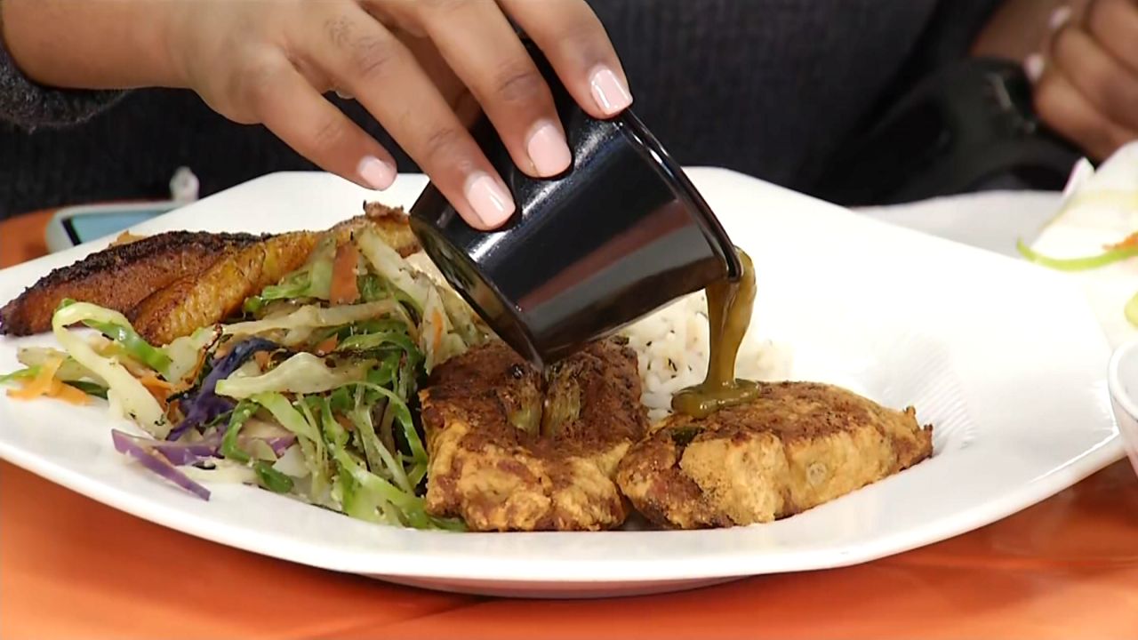 someone pours gravy or au jus on a dish of food