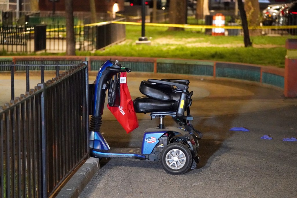 A mobility scooter with a red shopping bag hanging from the handlebars at the scene of a fatal shooting.