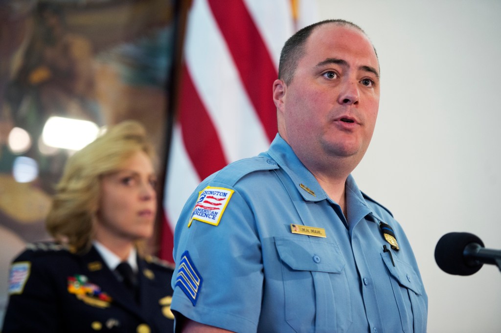 Sgt. Matthew Mahl speaking at a memorial service for fallen officers, with Police Chief Cathy Lanier in the background.