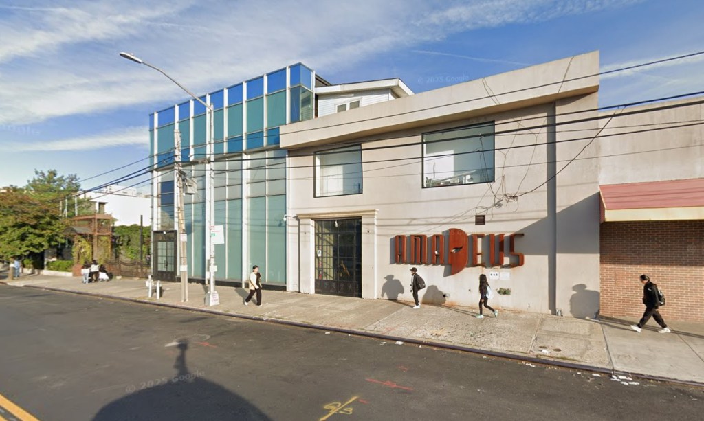 Street view of 7951 Albion Ave showing two multistory buildings, one with blue and frosted glass panels and the other a light beige color with "AMADEUS" in large orange letters on its side.