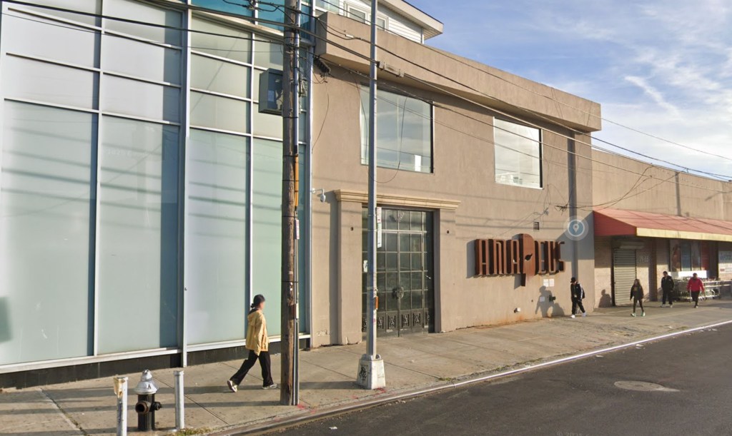 Street view of 7952 Albion Ave with a large brown building and a glass-paneled building on a street with pedestrians.