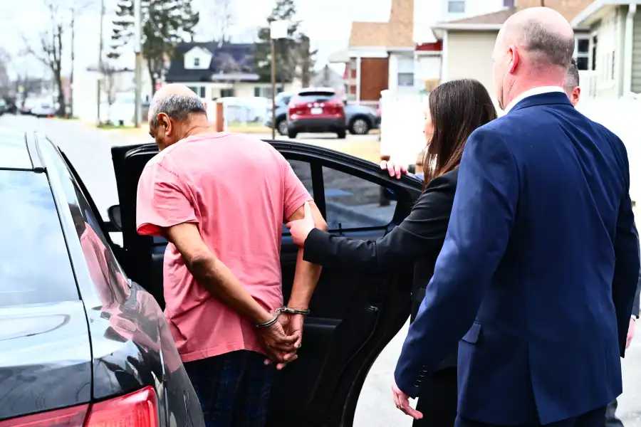 Detectives place Rupchand Simboo, 75, in the back of a waiting police car on March 11, 2026, after he was charged with murdering his wife. 