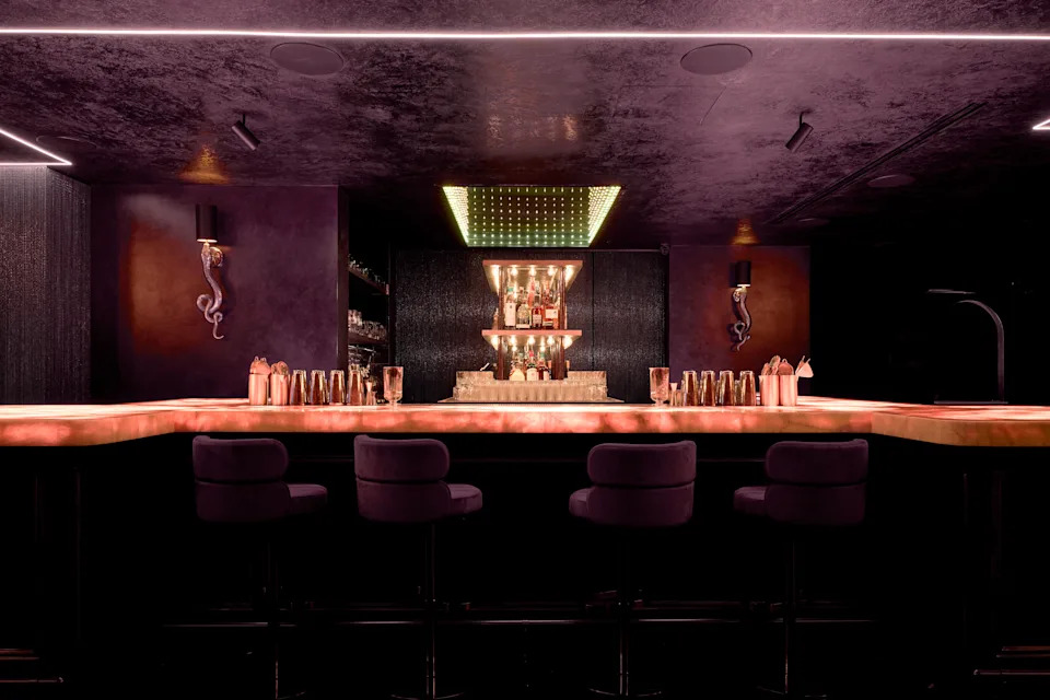 Interior of The Eighth cocktail bar in Chelsea NYC with moody lighting and immersive design