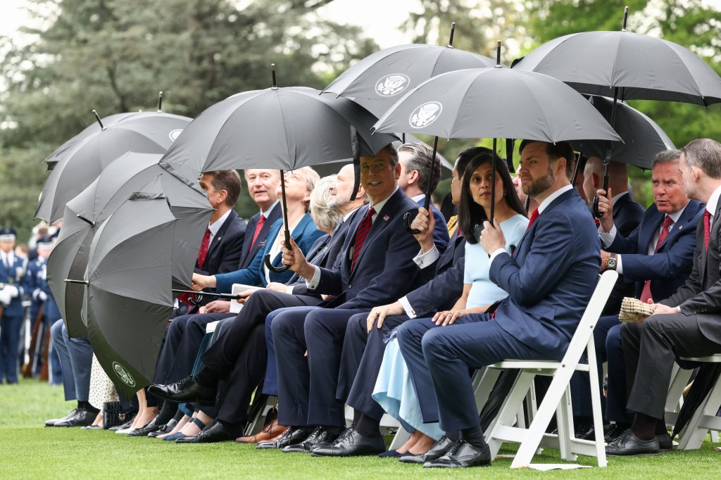 Vice President JD Vance, second lady Usha Vance, Secretary of the Treasury Scott Bessent, Commerce Secretary Howard Lutnick and Special Envoy Steve Witkoff shield themselves from rain as they attend the arrival ceremony.