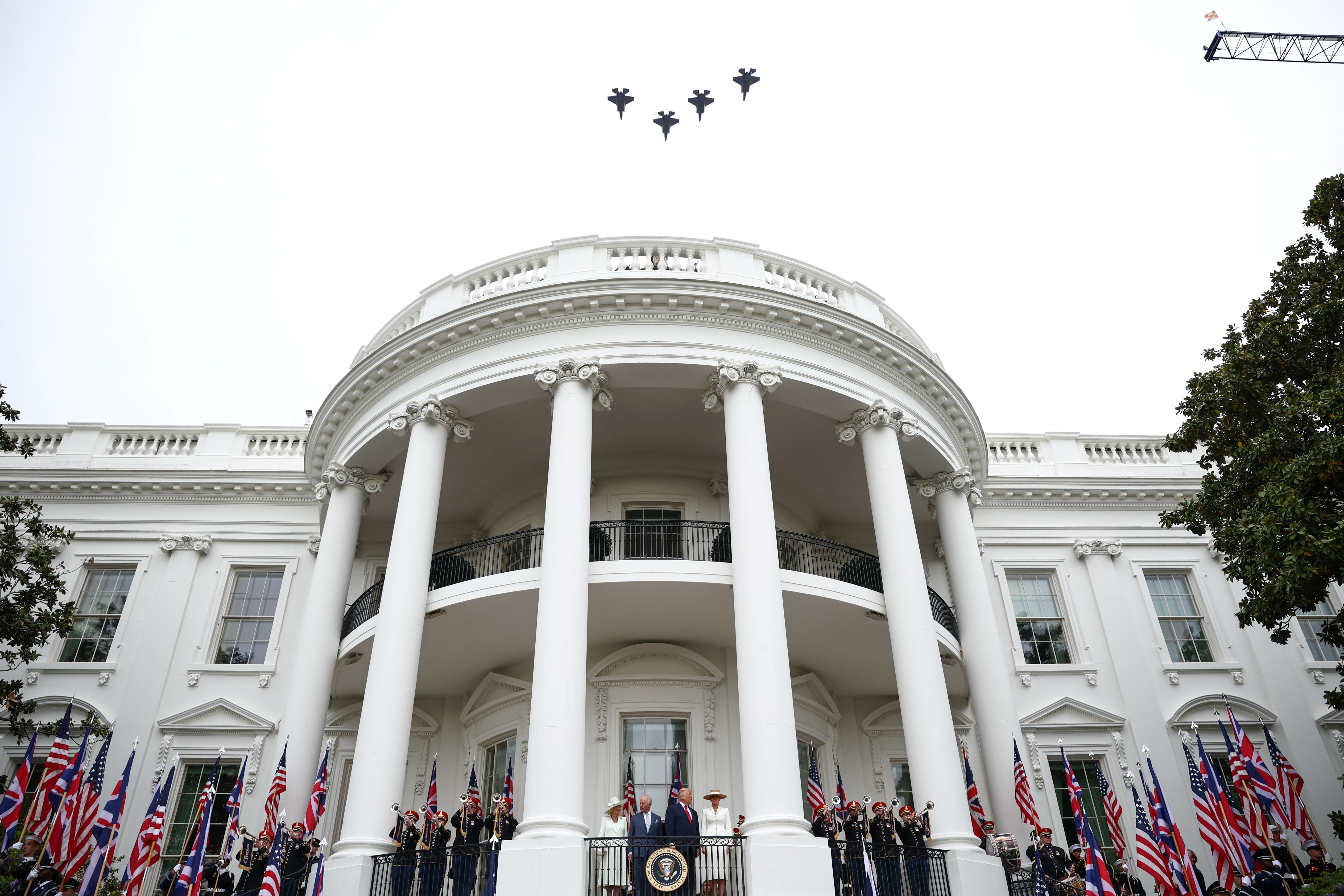 President Donald Trump, Melania Trump, King Charles III and Queen Camilla watch a flyover of military planes from the Blue Room balcony.
