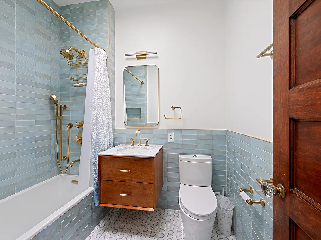 bathroom with pale blue subway tile, floating vanity