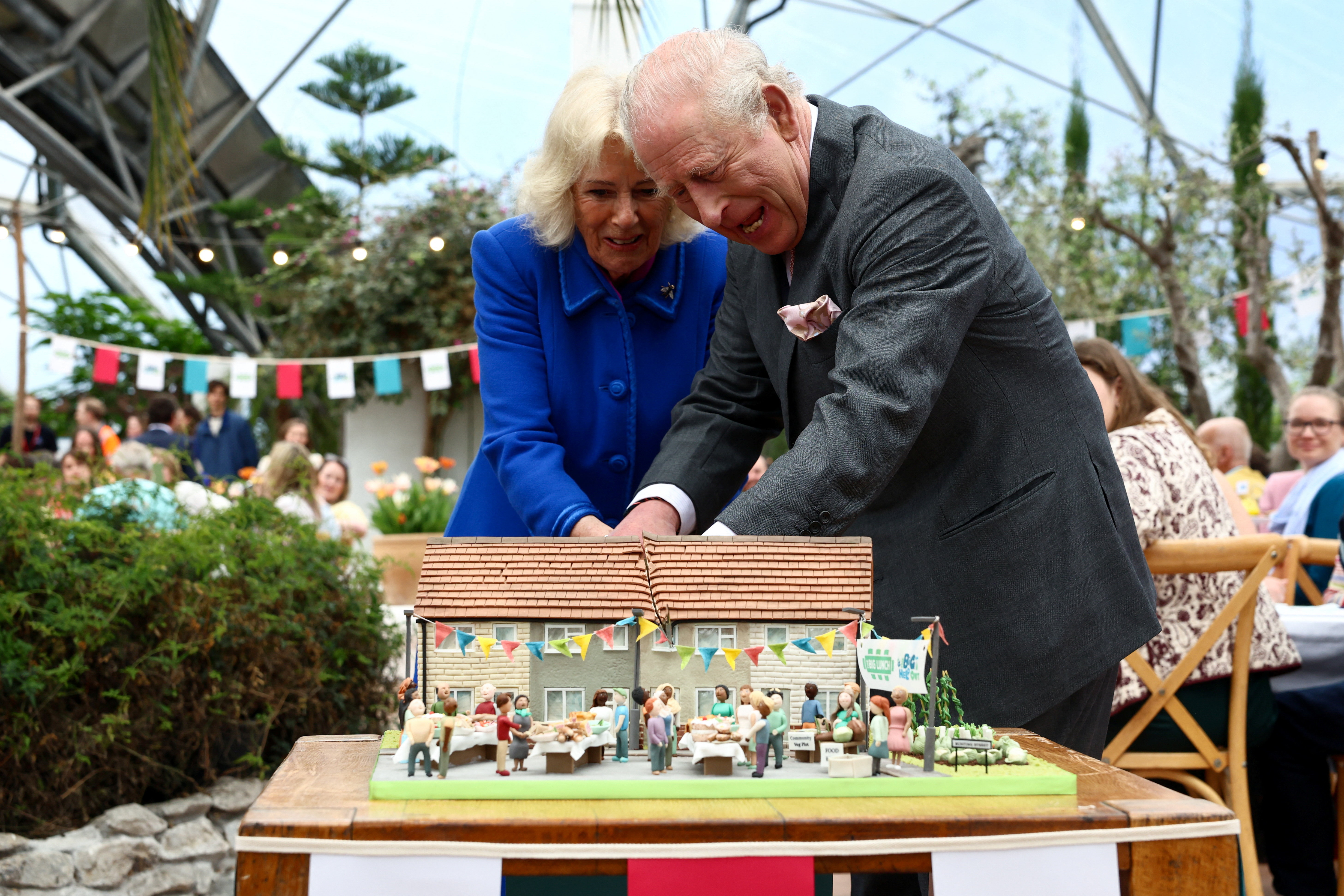 King Charles and Queen Camilla cutting a cake