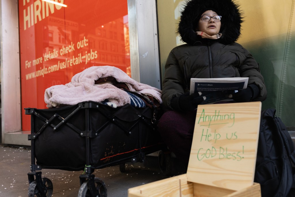 Homeless New Yorker Tiffany Rosario keeps warm in Midtown with her service dog while she has to be out of her shelter during the day,