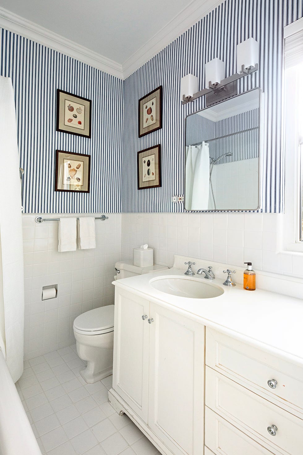 Bathroom with striped wallpaper and white fixtures. Bathroom with striped wallpaper and white fixtures.
