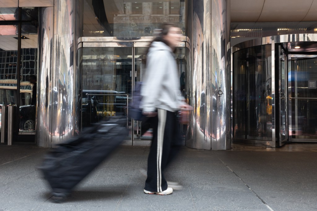 Tourists walk in and out of the Grand Central Hyatt hotel,