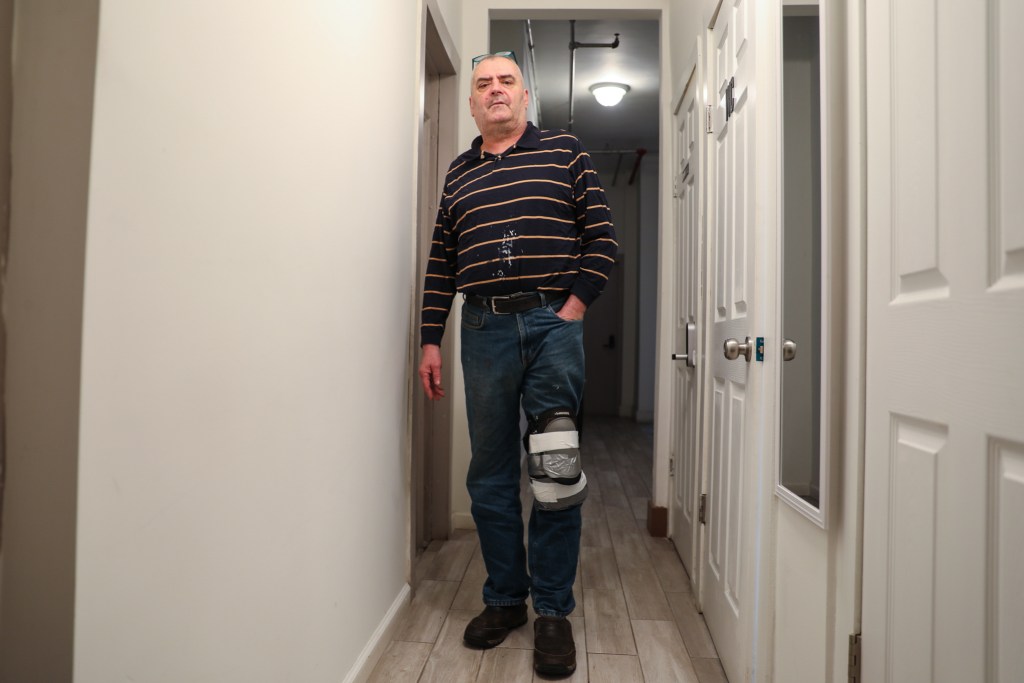 Garrat Kennedy wears a knee brace in his Hell's Kitchen single room occupancy apartment building.