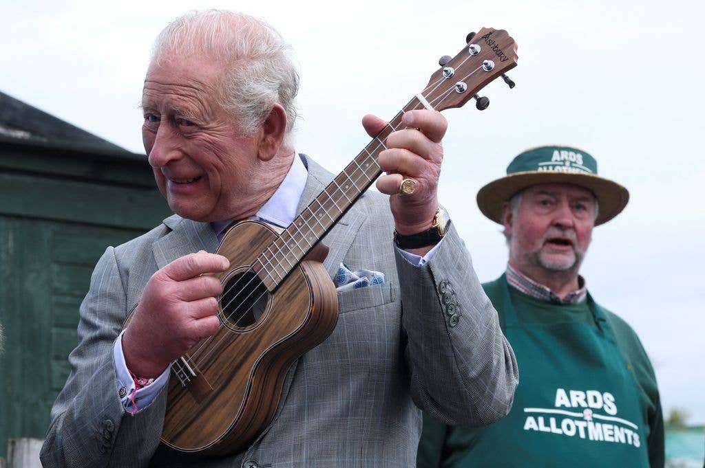 King Charles playing a ukulele