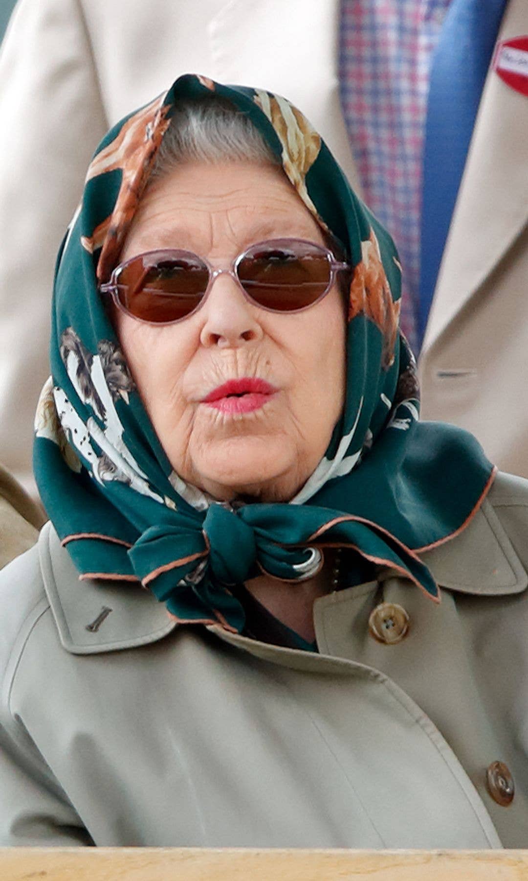 The Queen whistling in a headscarf with dog designs