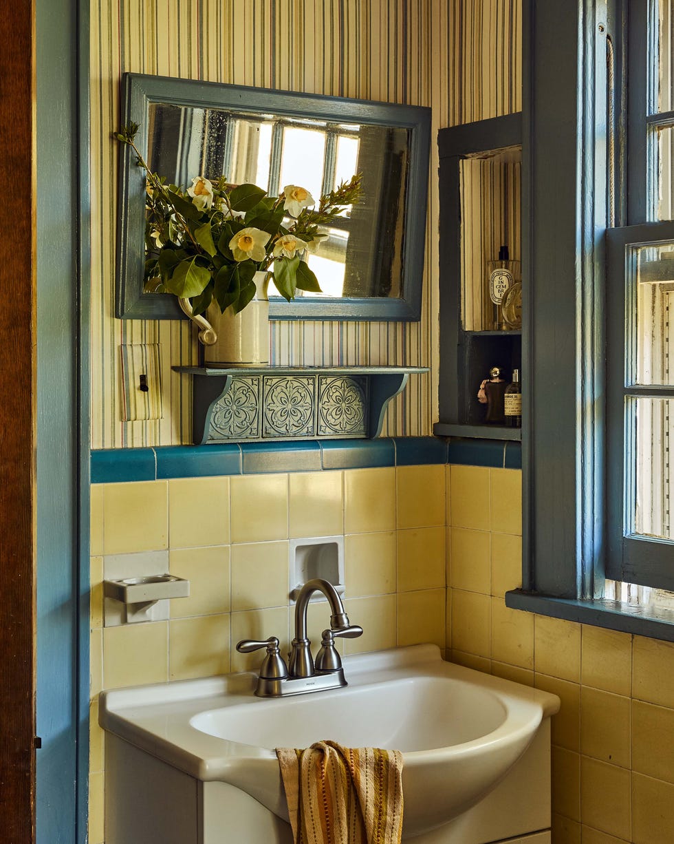 Bathroom with a sink, flowers, and a window