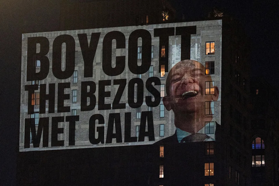 Activists project protest messages highlighting concerns of wealth inequality, climate accountability and labor rights onto the facade of a building that can be seen from Jeff Bezos' penthouse in New York City, U.S., May 3, 2026. REUTERS/David 'Dee' Delgado